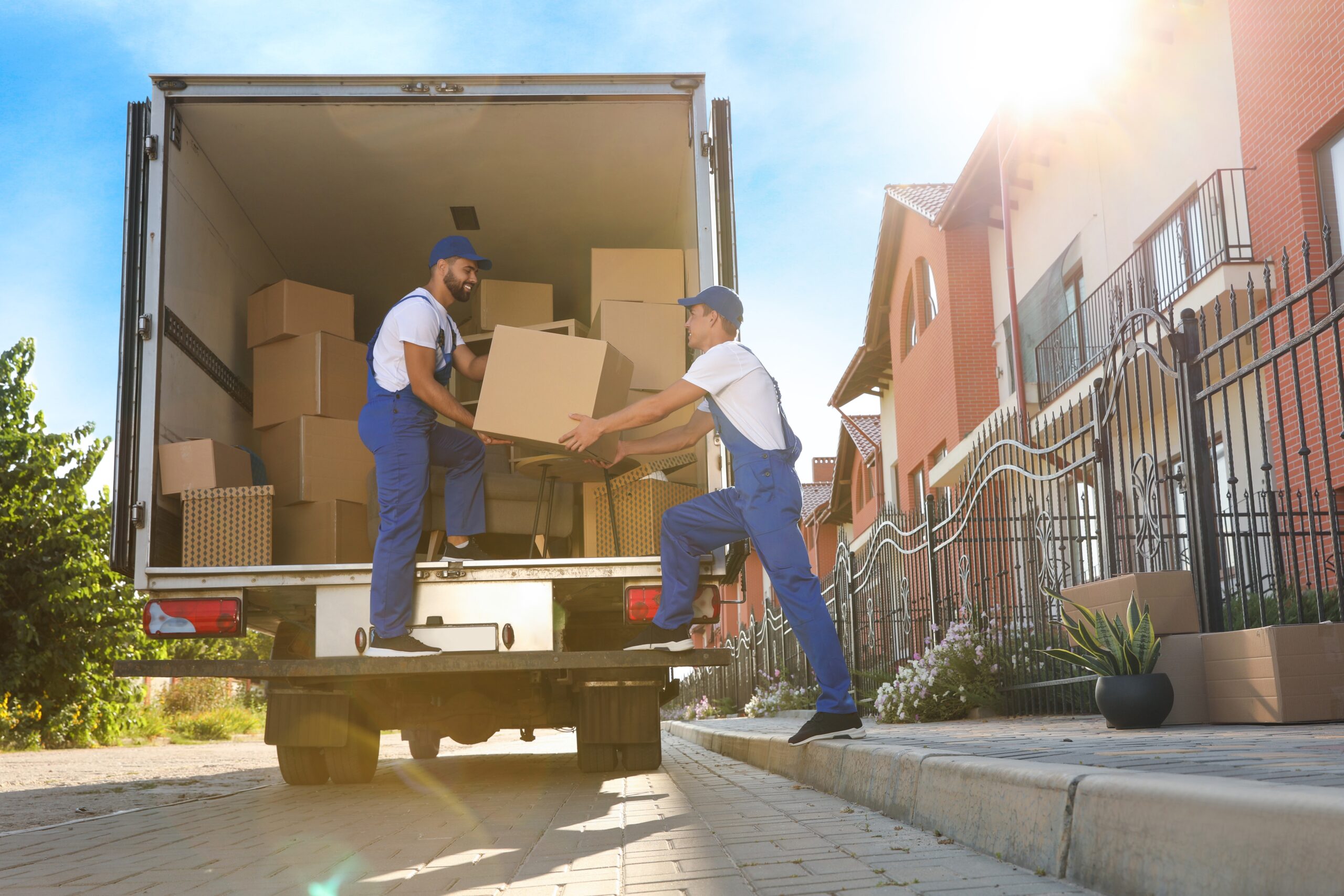 Moving crew organizing protected furniture and packed household boxes for a relocation